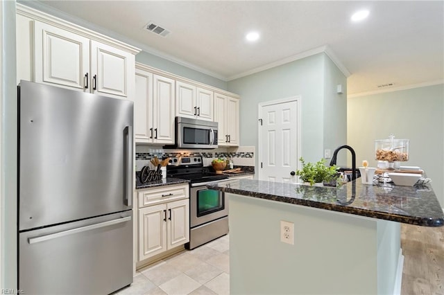 kitchen with visible vents, ornamental molding, a sink, backsplash, and stainless steel appliances