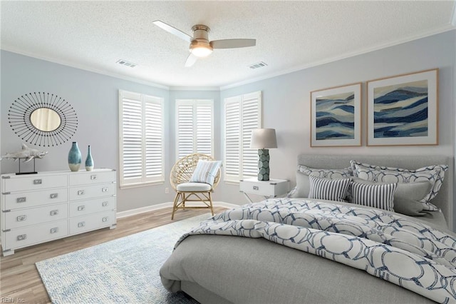 bedroom with a textured ceiling, visible vents, ornamental molding, and wood finished floors