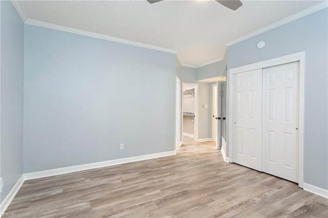 unfurnished bedroom with ceiling fan, wood finished floors, baseboards, a closet, and ornamental molding