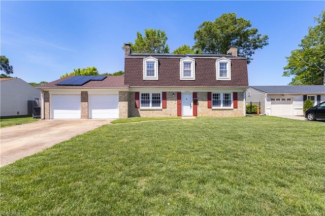 view of front of home featuring an attached garage, a front lawn, driveway, and a chimney