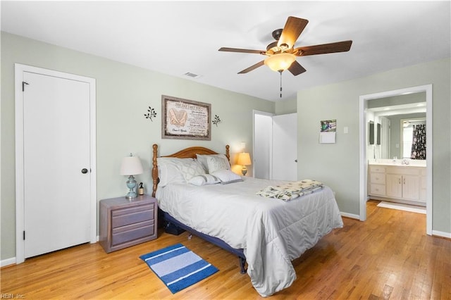 bedroom featuring a ceiling fan, baseboards, visible vents, and wood finished floors