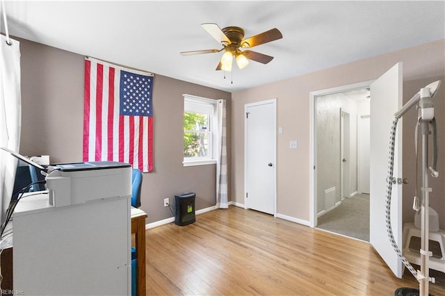bedroom with a ceiling fan, baseboards, and light wood finished floors