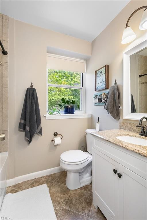 bathroom featuring vanity, toilet, tile patterned floors, baseboards, and bathing tub / shower combination