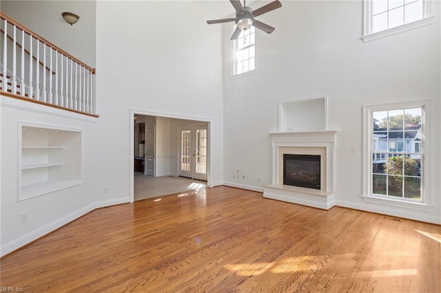 419 Hastings Pl, Suffolk, VA 23433 - unfurnished living room featuring ceiling fan, a wealth of natural light, built in shelves, and a towering ceiling