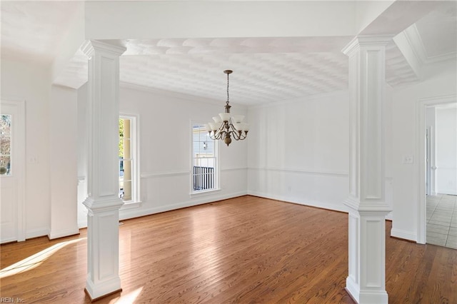 419 Hastings Pl, Suffolk, VA 23433 - unfurnished dining area with an inviting chandelier, baseboards, wood finished floors, ornate columns, and ornamental molding