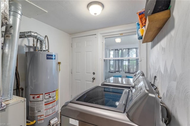 clothes washing area with separate washer and dryer, laundry area, and water heater