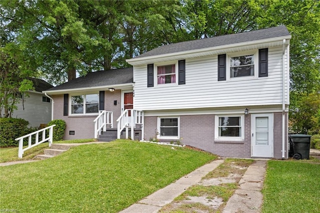 split level home featuring brick siding and a front yard
