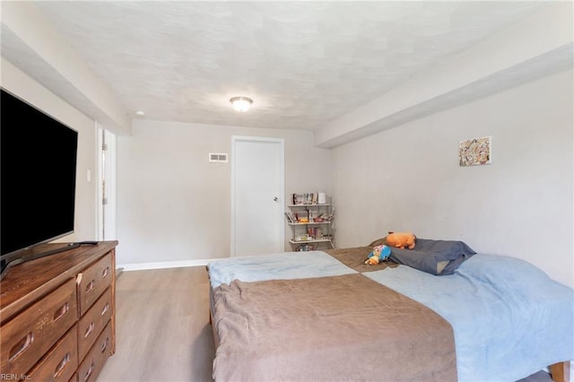 bedroom with light wood-style floors, baseboards, and visible vents
