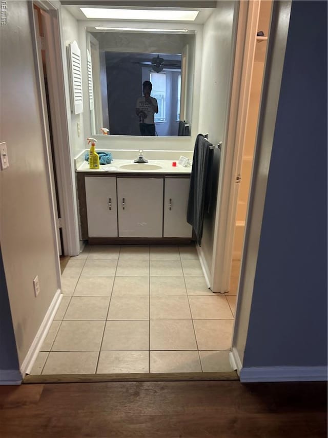 bathroom with baseboards, tile patterned floors, and vanity