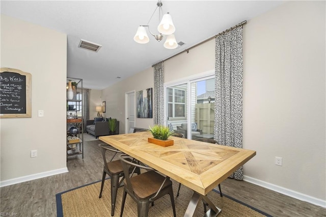 dining room featuring baseboards, wood finished floors, a chandelier, and visible vents