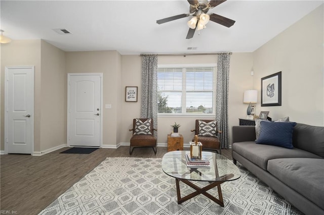 living area with visible vents, baseboards, ceiling fan, and wood finished floors