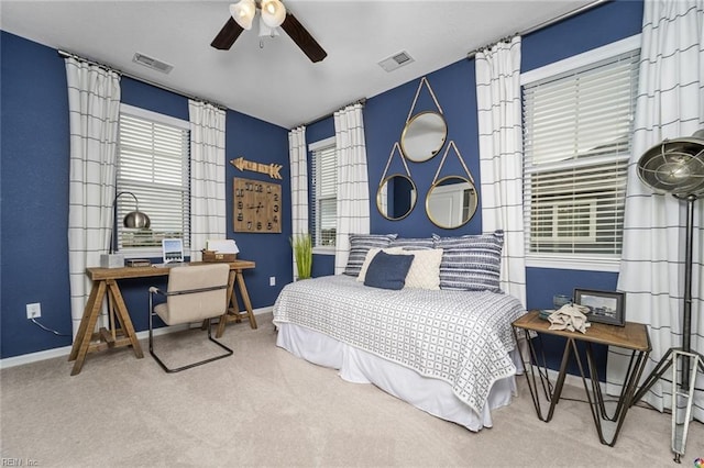 carpeted bedroom featuring baseboards, visible vents, and multiple windows
