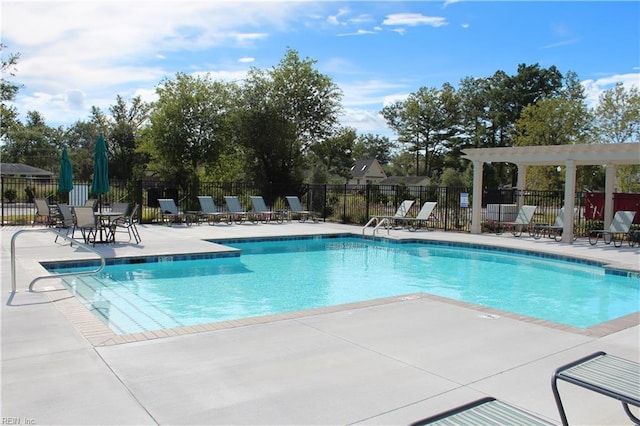 pool with a patio and fence