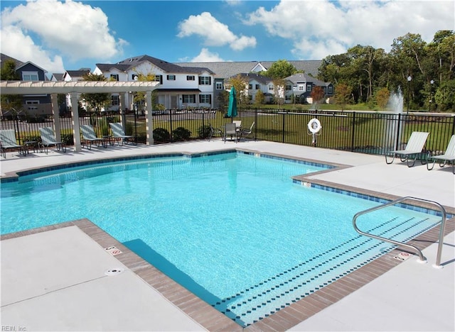 community pool with a pergola, fence, a residential view, and a patio area