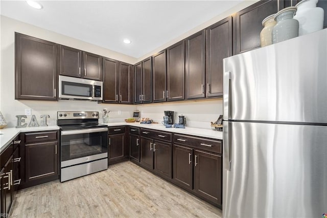 kitchen with light countertops, stainless steel appliances, light wood-style flooring, and dark brown cabinets