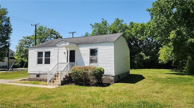 bungalow-style home featuring a shingled roof, a front yard, and crawl space