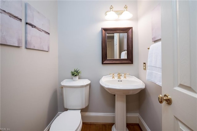 1263 Murphys Mill Rd, Suffolk, VA 23434 - half bath featuring toilet, baseboards, a sink, and wood finished floors