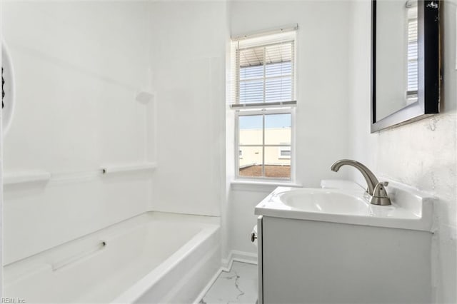 bathroom featuring vanity, marble finish floor, washtub / shower combination, and baseboards