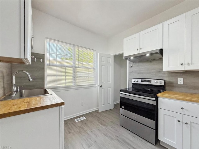 kitchen featuring a sink, wooden counters, under cabinet range hood, and electric stove