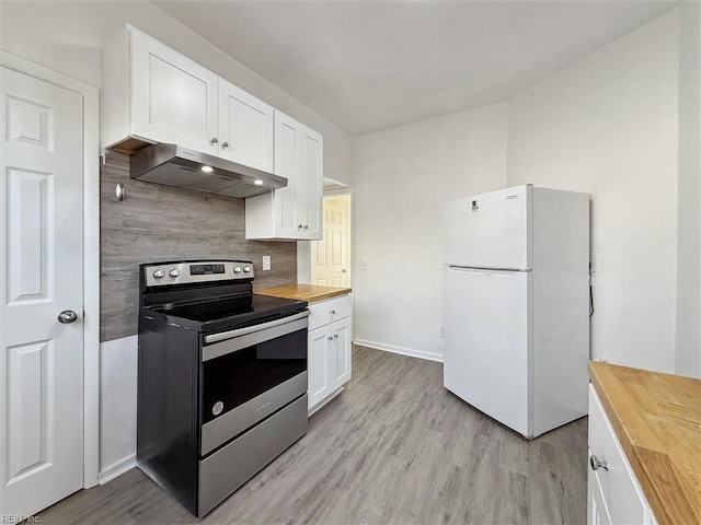 kitchen featuring freestanding refrigerator, stainless steel electric range, under cabinet range hood, tasteful backsplash, and wood counters
