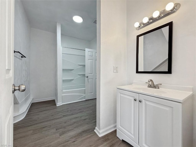 bathroom featuring baseboards, wood finished floors, and vanity