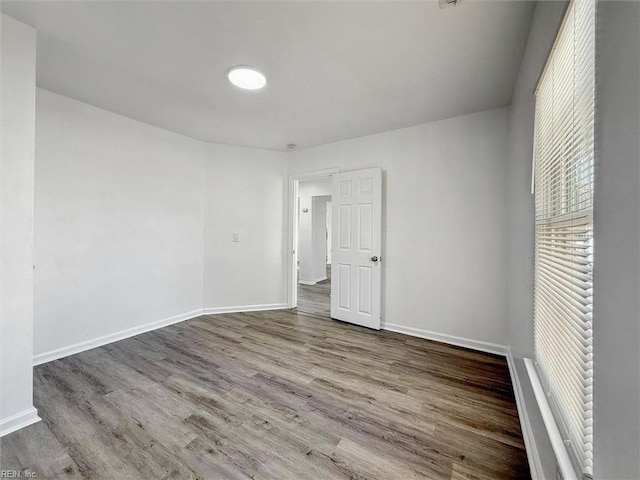 unfurnished bedroom with baseboards and wood finished floors