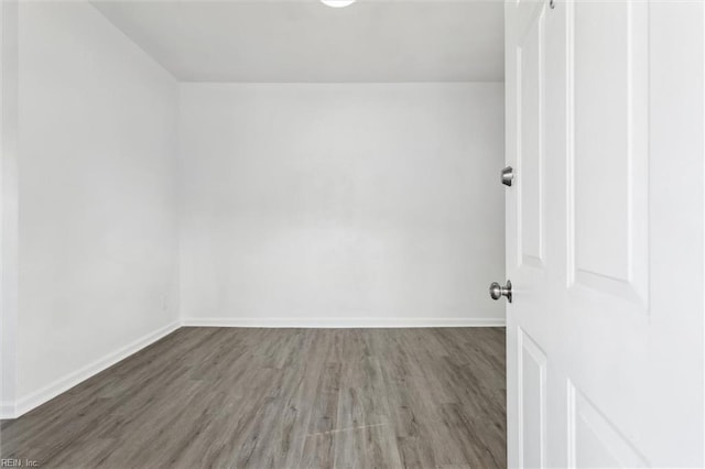 empty room featuring baseboards and wood finished floors