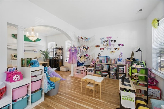 1728 Eleni Ct, Virginia Beach, VA 23453 - playroom featuring decorative columns, visible vents, arched walkways, wood finished floors, and an inviting chandelier