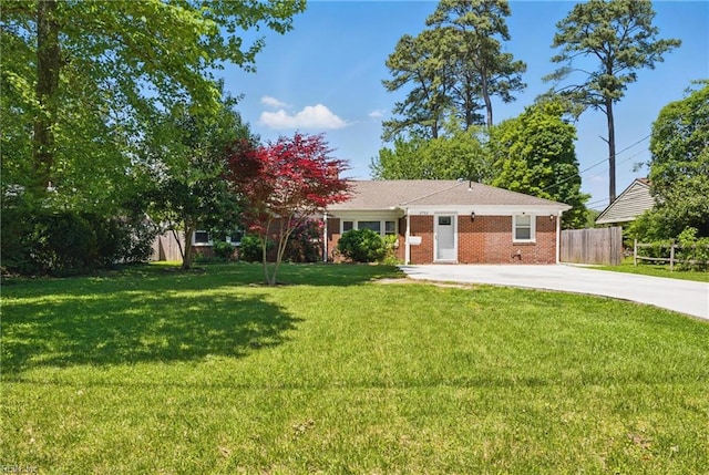 view of front of property with fence, driveway, brick siding, and a front yard