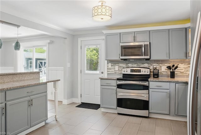 kitchen featuring crown molding, gray cabinets, and appliances with stainless steel finishes