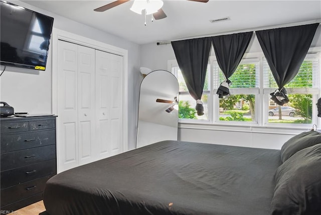 bedroom with a ceiling fan, a closet, light wood-style flooring, and visible vents