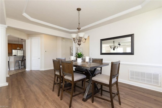 dining room featuring dark wood-style flooring, a notable chandelier, visible vents, and ornamental molding