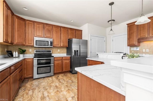 kitchen featuring brown cabinetry, backsplash, decorative light fixtures, and stainless steel appliances