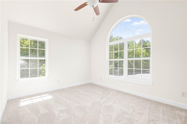 carpeted empty room with baseboards, a ceiling fan, and vaulted ceiling