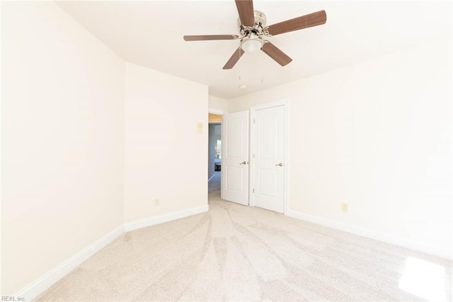 empty room featuring baseboards and light carpet