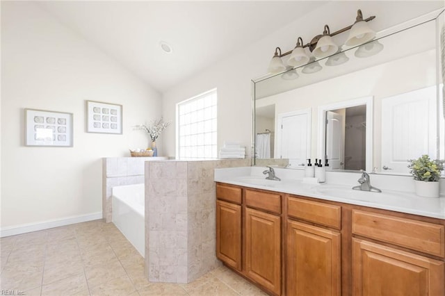 bathroom with a sink, a garden tub, double vanity, and lofted ceiling