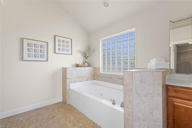 full bathroom with a whirlpool tub, baseboards, vaulted ceiling, and vanity