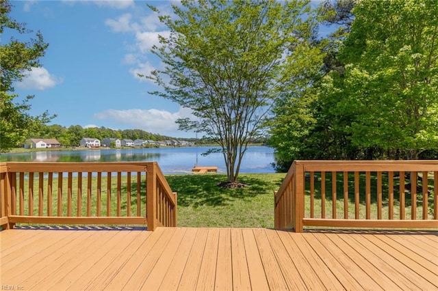 wooden deck with a water view and a yard