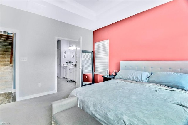 bedroom with carpet floors, baseboards, and ensuite bath