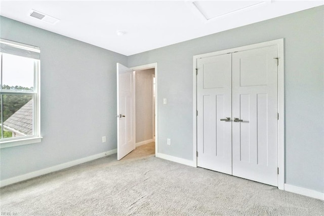 unfurnished bedroom featuring carpet flooring, baseboards, visible vents, and a closet