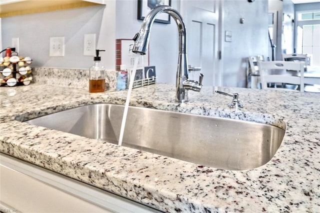 room details featuring a sink and light stone countertops