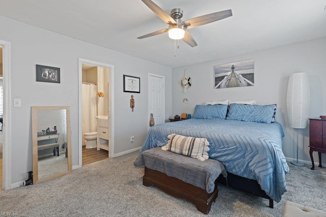 carpeted bedroom with a ceiling fan, baseboards, and ensuite bath