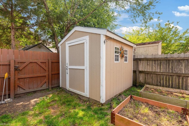 view of shed with a fenced backyard and a vegetable garden