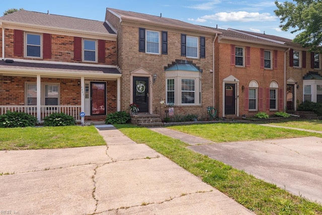 view of property with brick siding and a front yard