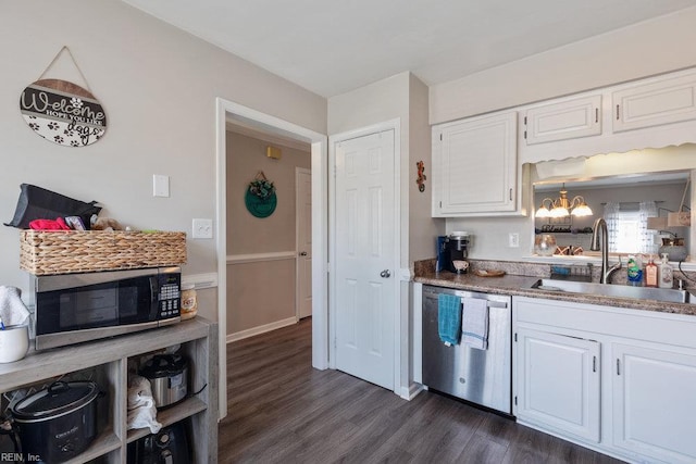 kitchen featuring dark wood-style floors, white cabinetry, a chandelier, a sink, and appliances with stainless steel finishes