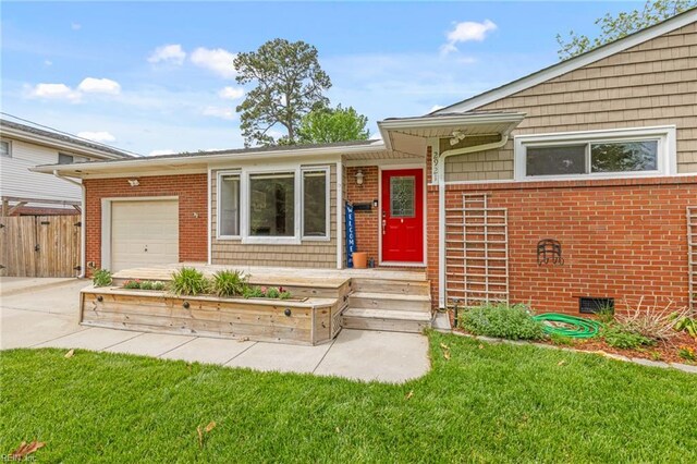 ranch-style home with fence, an attached garage, brick siding, a front yard, and driveway