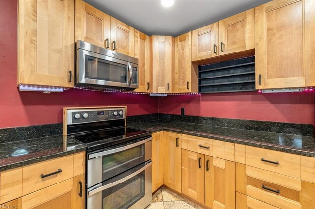 kitchen featuring dark stone counters and appliances with stainless steel finishes