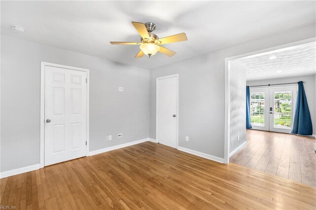 empty room featuring baseboards, ceiling fan, french doors, and hardwood / wood-style floors