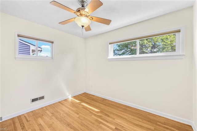 unfurnished room featuring ceiling fan, baseboards, visible vents, and light wood-style flooring