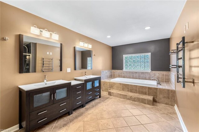 full bathroom featuring tile patterned flooring, a sink, a bath, and two vanities